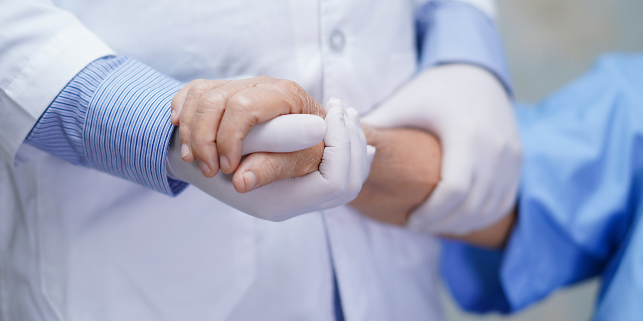 Doctor holding hands of a patient.