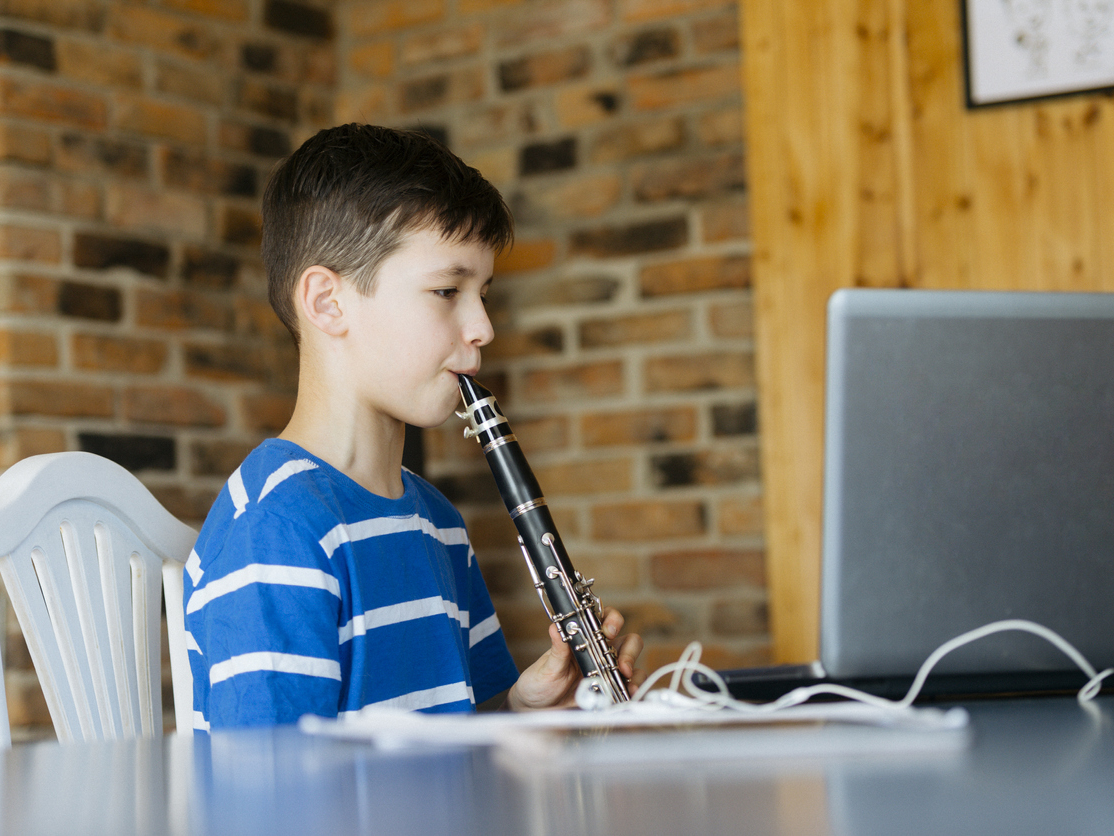 Boy with a clarinet plays music in virtual band camp.