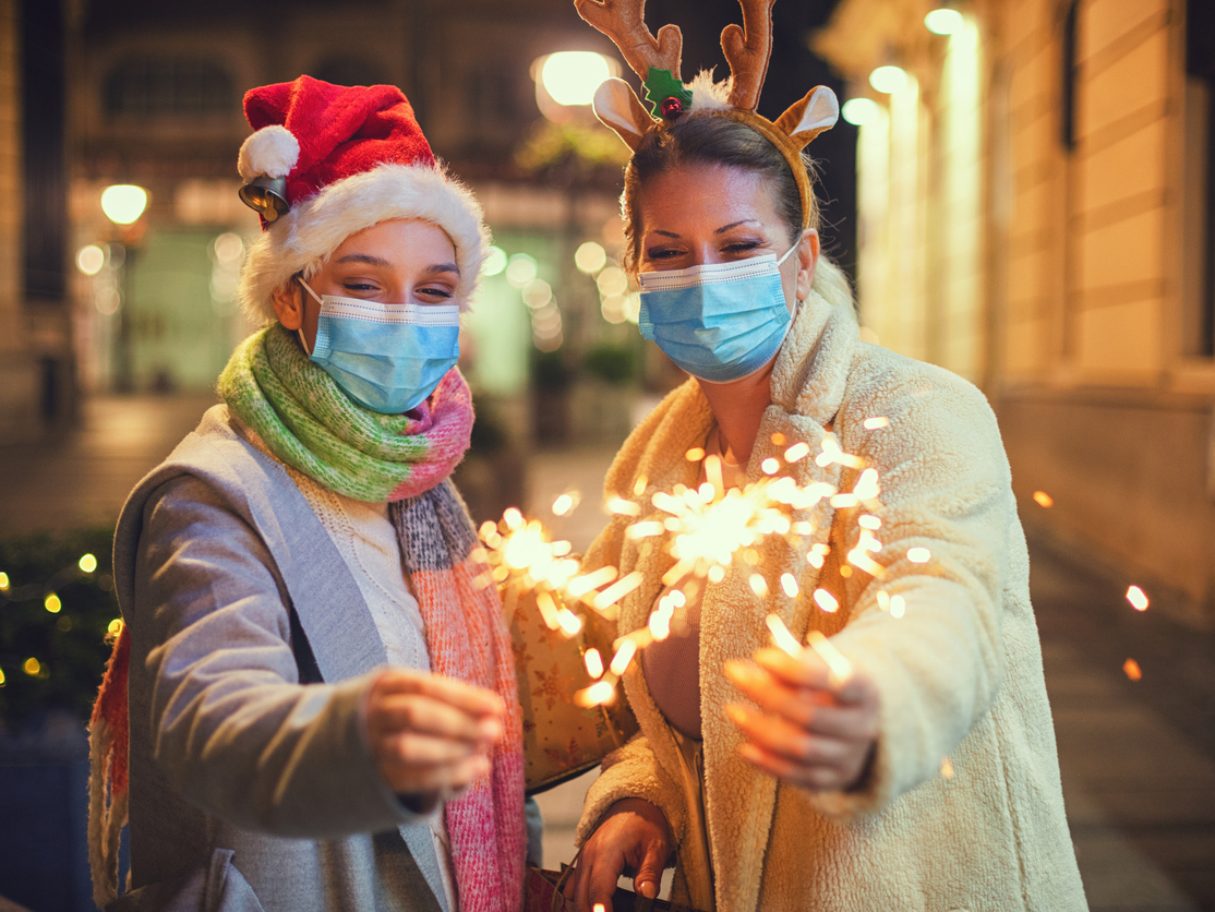 Two women hold sparklers as they celebrate the winter holidays.