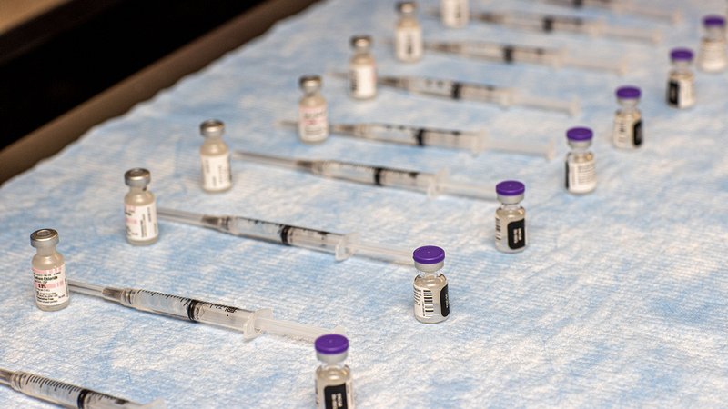 syringes of COVID-19 vaccine get prepared for vaccination clinic.